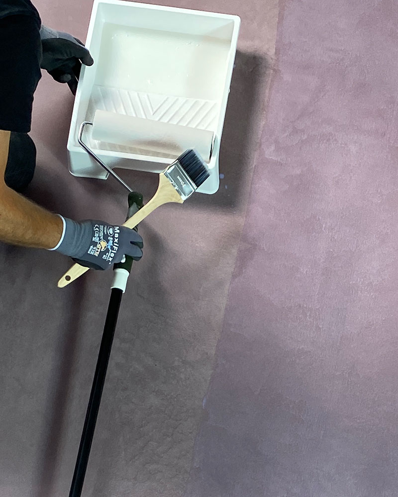 Sørg for at overflaten er tørr og ren innen påføring av lakk. Hell lakken over på et malebrett og påfør med pensel ved kantene og en rulle over de store arealene.